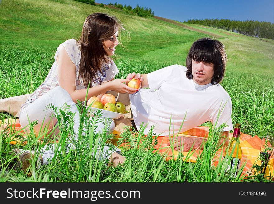 Nice girl with fruit and boy on grass