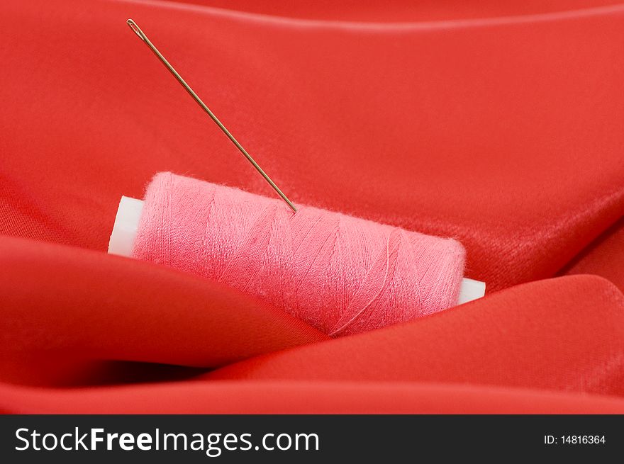 Ball Of Threads On A Red Fabric