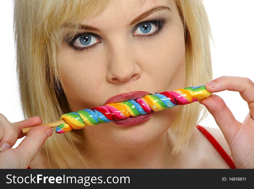 Pretty blond enjoys her multicolored candy stick. Pretty blond enjoys her multicolored candy stick