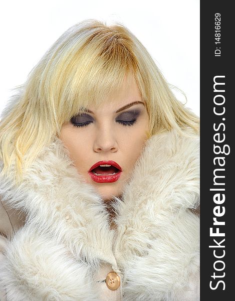 Blond model in a fur coat isolated on white. Blond model in a fur coat isolated on white