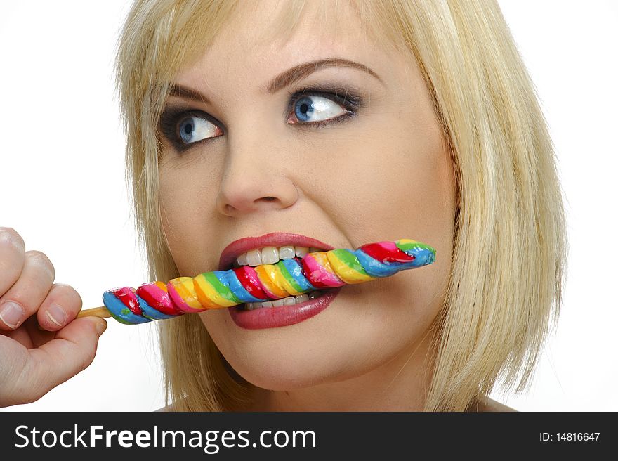 Pretty blond eats a multicolored candy stick. Pretty blond eats a multicolored candy stick