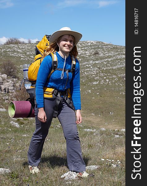 Girl in blue jacket with yellow backpack walking outdoor