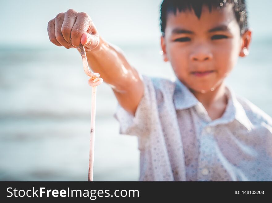 Children holding Plastic straw that he found on the beach