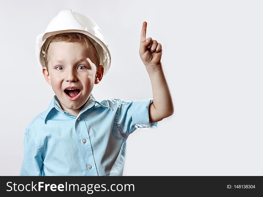 Boy In The Light Blue Shirt And Construction Helmet Of The Foreman Raised A Finger, As If He Had Found The Idea