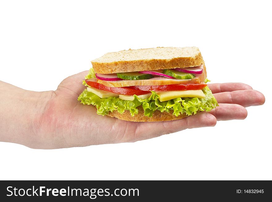 Sandwich with ham, tomato, radish, cucumber and cheese in the hand isolated over white background. Sandwich with ham, tomato, radish, cucumber and cheese in the hand isolated over white background