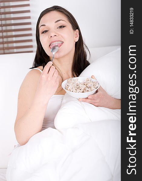 Young adult woman with corn flakes in bed. Young adult woman with corn flakes in bed