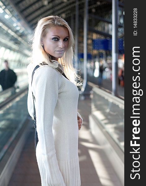 Young blond woman with shoulder bag and knitted dress