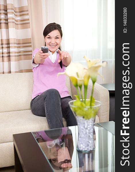Young adult woman with remote control at home. Young adult woman with remote control at home