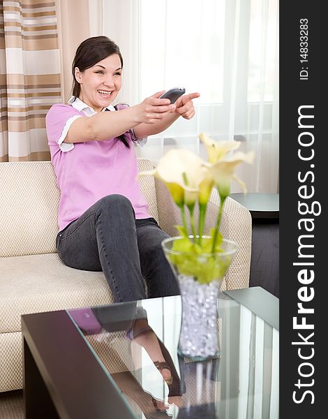 Young adult woman with remote control at home. Young adult woman with remote control at home