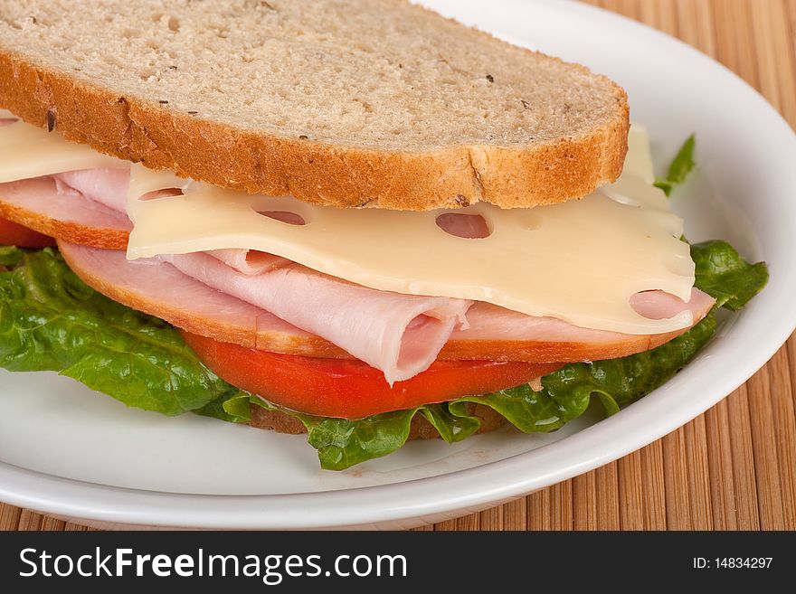 Closeup of a ham and swiss cheese sandwich with tomato and lettuce on rye bread. Closeup of a ham and swiss cheese sandwich with tomato and lettuce on rye bread