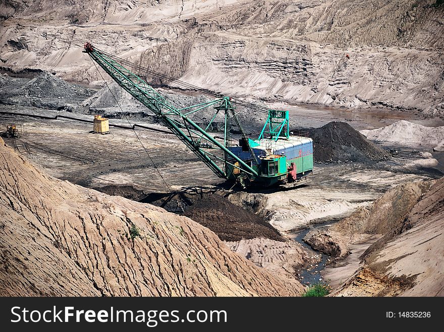 Excavator in amber open pit