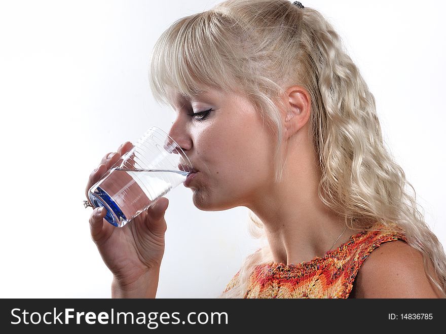 Blond woman drinking a glass of water. Blond woman drinking a glass of water