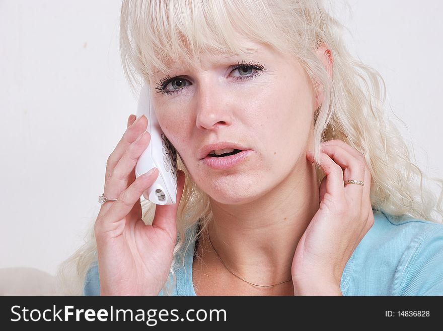 A blond woman phoning at home