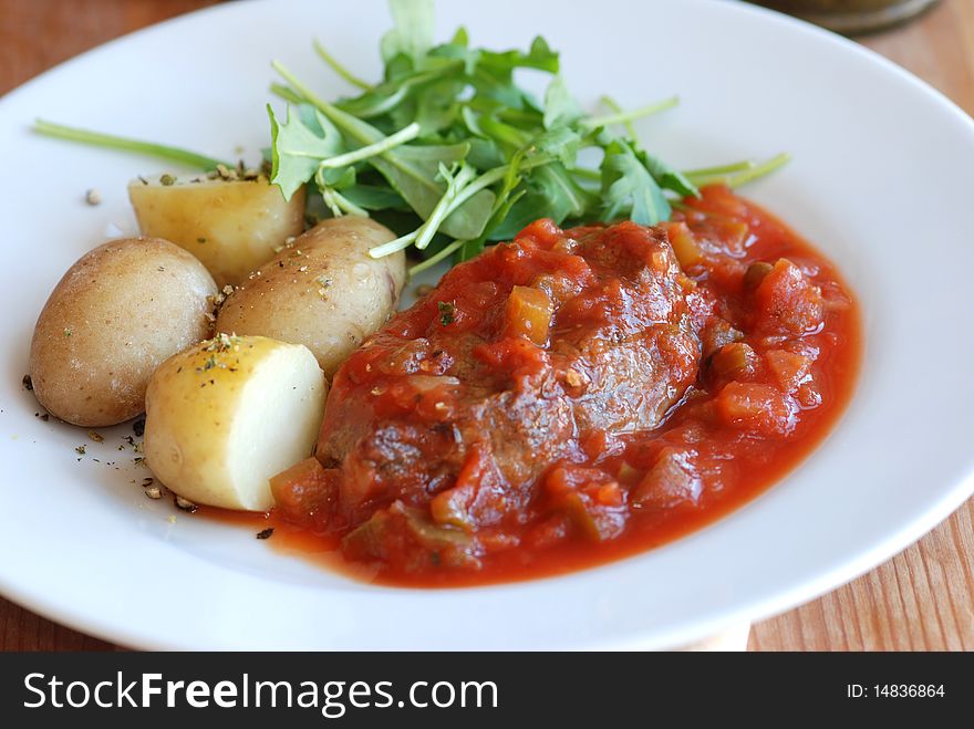 Sirloin steak with pizzaiola sauce and new potatoes. Sirloin steak with pizzaiola sauce and new potatoes