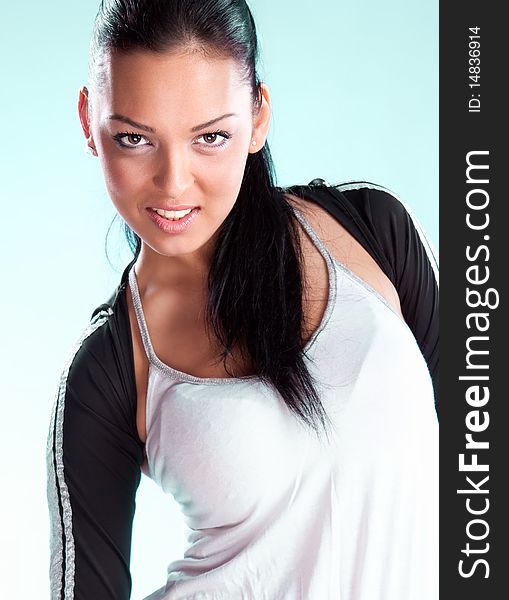 Pretty brunette wearing sport outfit and looking down, studio shot