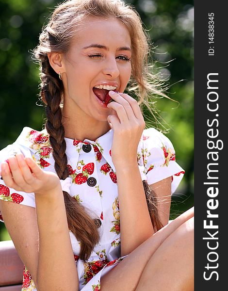 Portrait of the beautiful girl with a strawberry