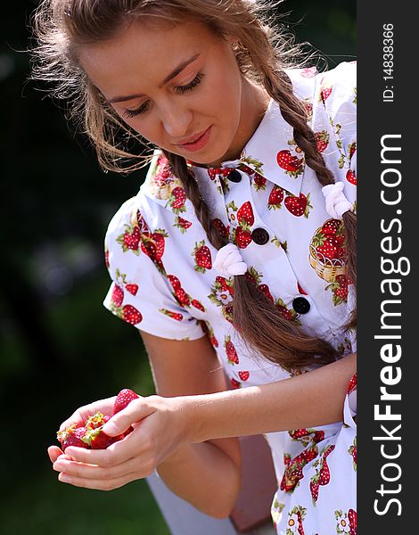 Portrait of the beautiful girl with a strawberry