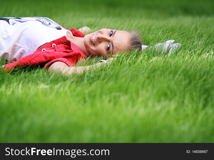 Cute young female lying on grass field at the park. Cute young female lying on grass field at the park