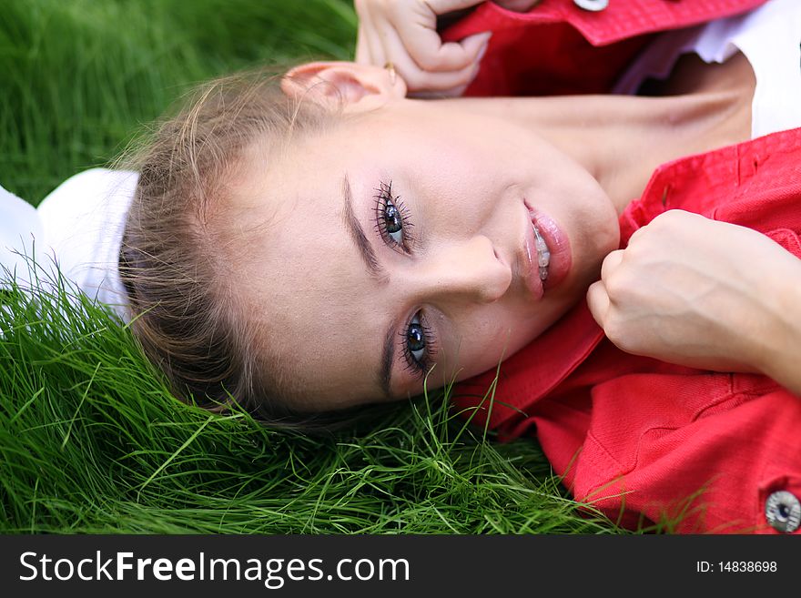 Cute young female lying on grass field at the park. Cute young female lying on grass field at the park