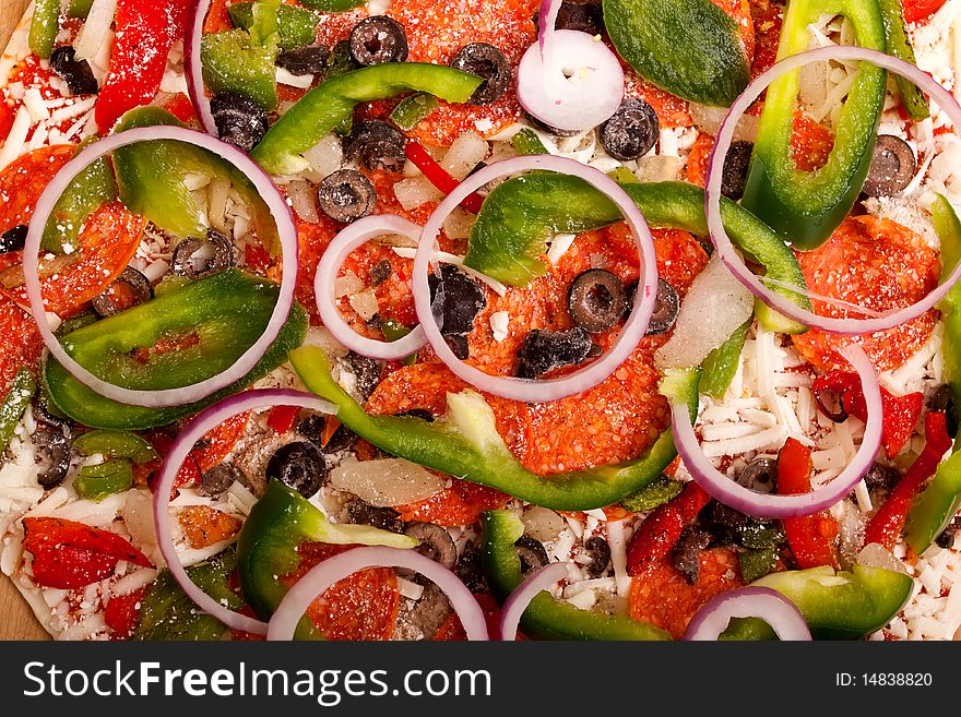 Raw pizza with vegetables and pepperoni