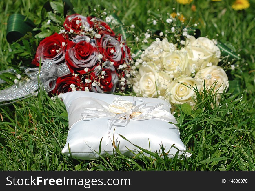 White and red roses bouqet and some rings in the grass. White and red roses bouqet and some rings in the grass.