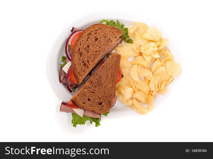 Delicious roast beef sandwich platter with whole wheat bread and potato chips. Delicious roast beef sandwich platter with whole wheat bread and potato chips