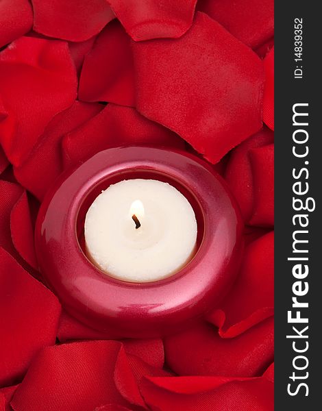 Candle surrounded with red rose petals. Candle surrounded with red rose petals