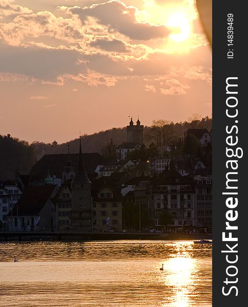 Scenic view of sunset over lake Lucerne and the historic city of Lucerne silhouetted in background, Switzerland. Scenic view of sunset over lake Lucerne and the historic city of Lucerne silhouetted in background, Switzerland.