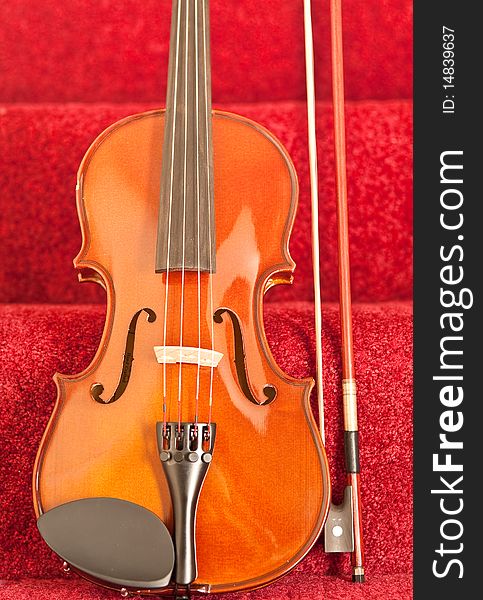 Violin leaned against red carpeted stairway. Violin leaned against red carpeted stairway