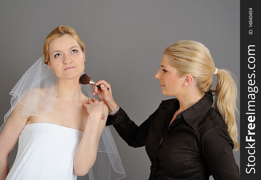 Natural Wedding make-up is being applied to pretty bride. gray background. Natural Wedding make-up is being applied to pretty bride. gray background