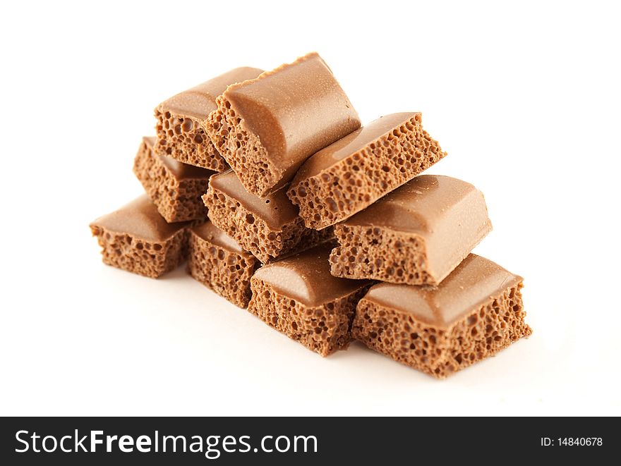 Tower of pieces of porous chocolate isolated on white