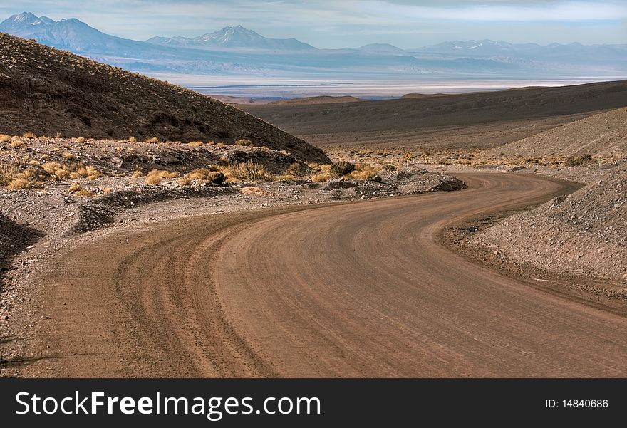 A curve in the middle of the desert, with mountains behind. A curve in the middle of the desert, with mountains behind