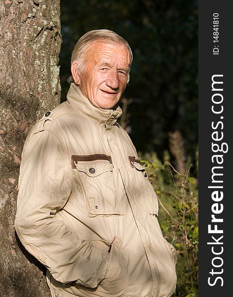Portrait of the grey-haired elderly man in a beige jacket in village on the nature. Portrait of the grey-haired elderly man in a beige jacket in village on the nature