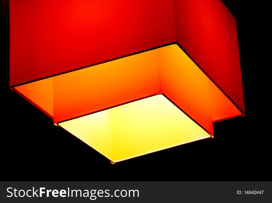 An orange shade Lamp with black background