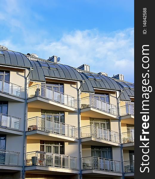 Exterior of modern apartment building with blue sky in the background. Exterior of modern apartment building with blue sky in the background.