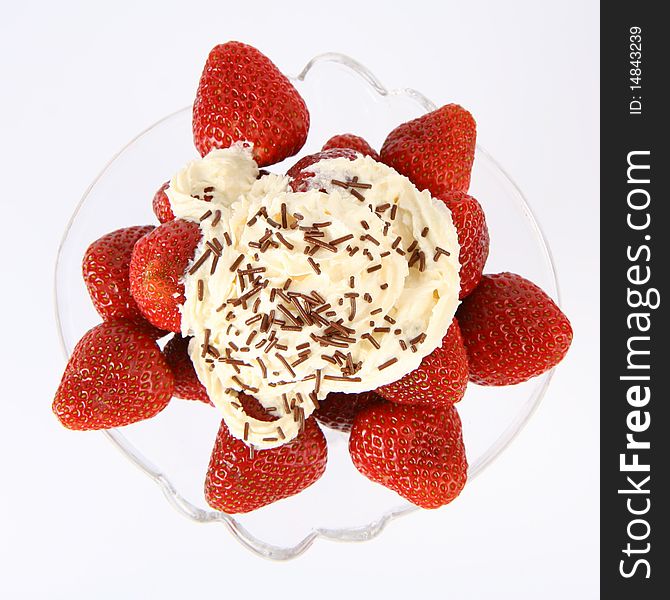 Strawberries in a glass cup with whipped cream and chocolate sprinkles in close up. Strawberries in a glass cup with whipped cream and chocolate sprinkles in close up