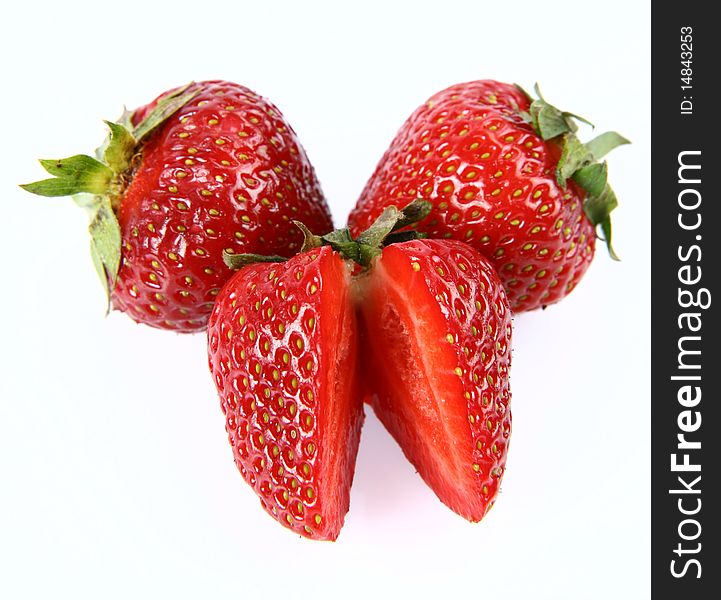 Strawberries on white background (two whole ones and one cut in half)