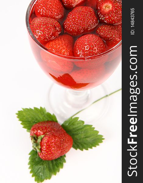 Jelly with strawberries decorated with a strawberry on a leaf in a cup