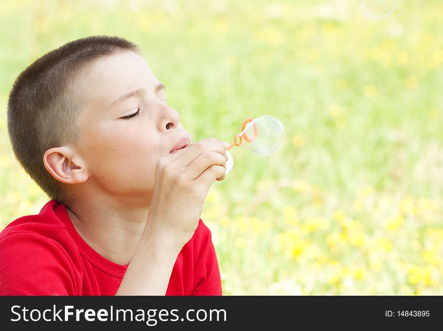 Boy blowing bubbles at the park