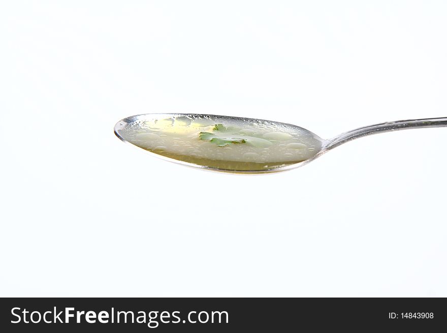 Chicken soup decorated with parsley on a spoon. Chicken soup decorated with parsley on a spoon