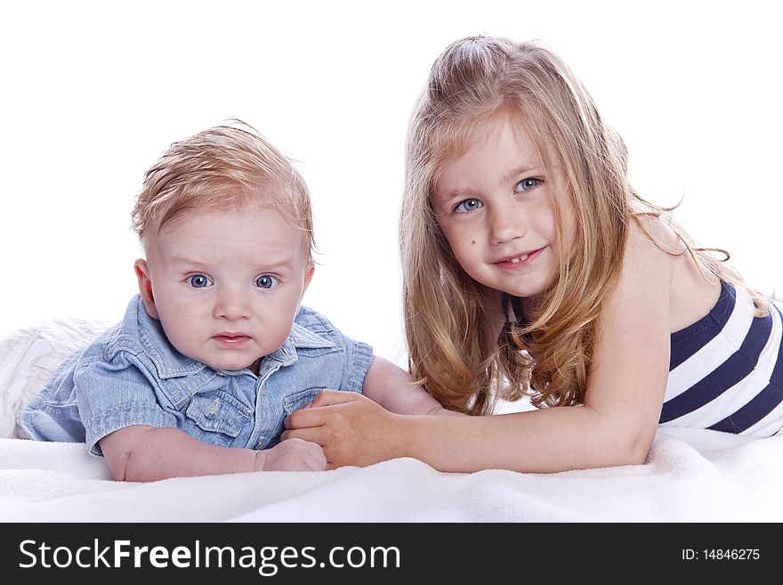 Brother and sister lying on bed with isolated background