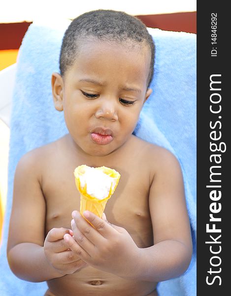 Child holding ice cream cone looking surprise while sitting in hot summer sun. Child holding ice cream cone looking surprise while sitting in hot summer sun