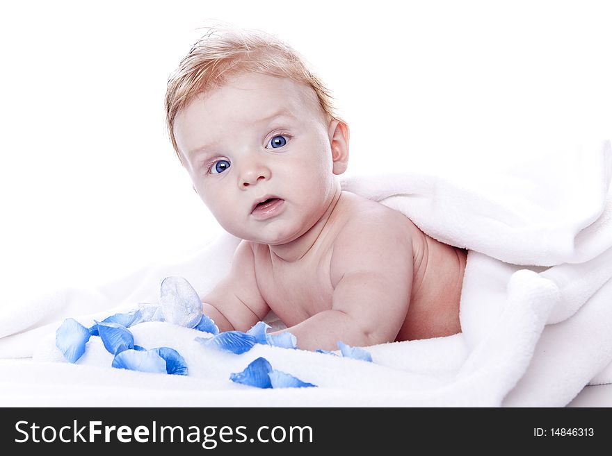 Baby in bed of flowers on white background