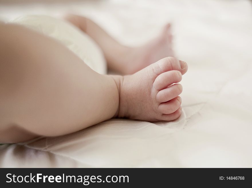 Newborn baby feet on a white blanket