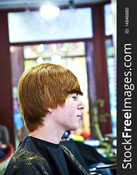 Smiling young boy with red hair at the hairdresser. Smiling young boy with red hair at the hairdresser