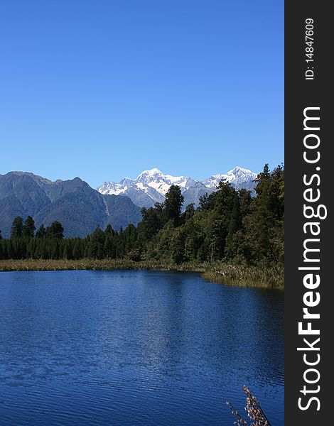 Mt Cook over the blue waters of Lake Matheson. Mt Cook over the blue waters of Lake Matheson.