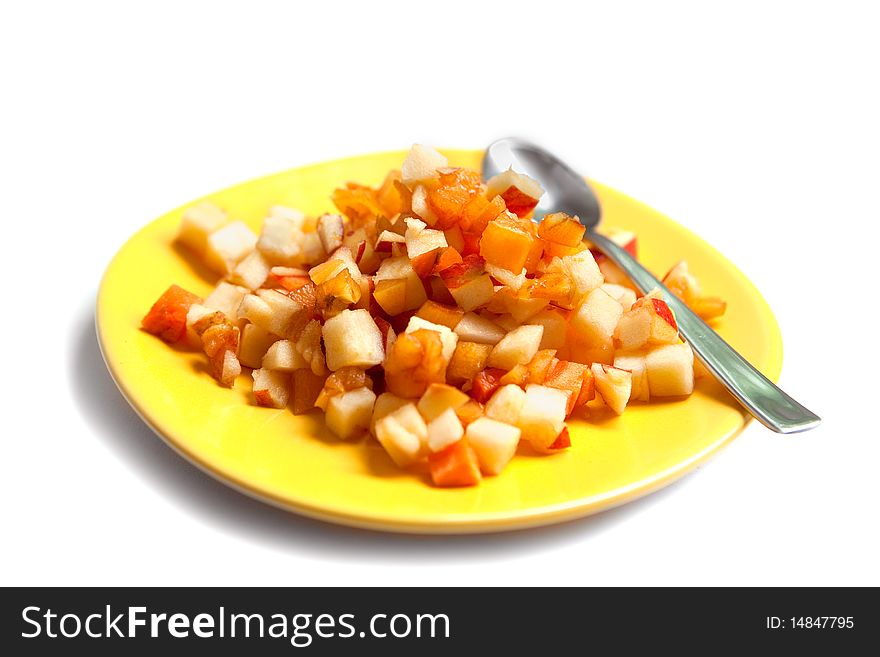 Fruit salad on yellow plate with a spoon isolated on white. Fruit salad on yellow plate with a spoon isolated on white