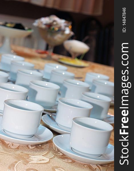 A lot of white cups for coffee or tea on a table