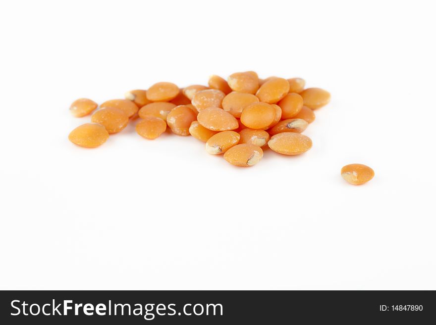 Group of red lentils on white background.