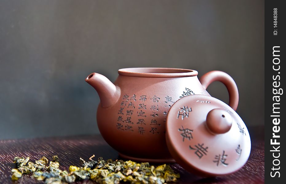 Chinese teapot and tea leaf on wooden table
